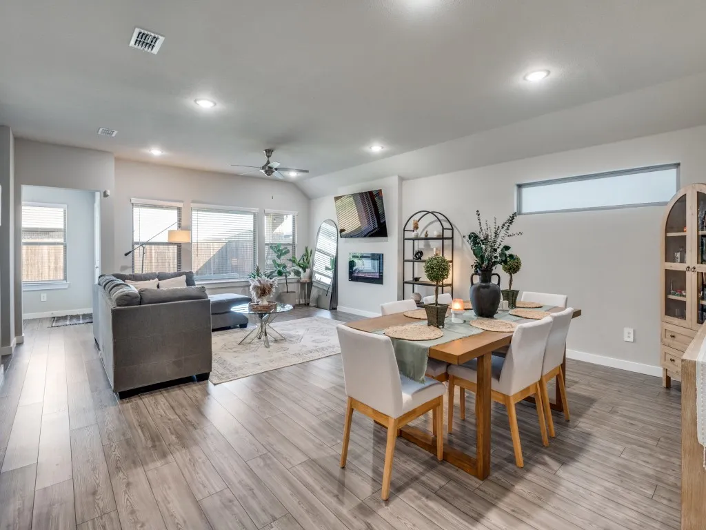 Open-concept living and dining area featuring wood-finish flooring, recessed lighting, and a ceiling fan