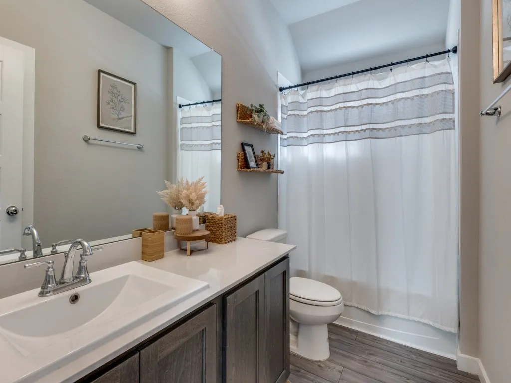 Bathroom featuring a single vanity with a white countertop, undermount sink, and chrome faucet