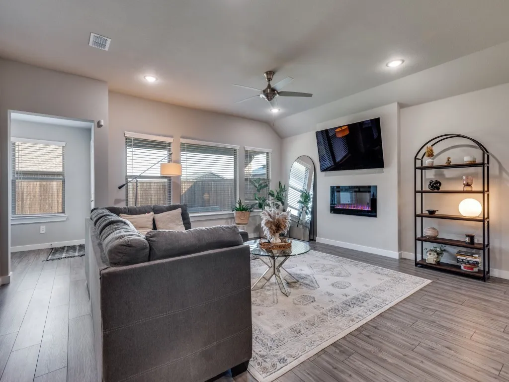 Spacious living area featuring wood-finish flooring, recessed lighting, and a ceiling fan