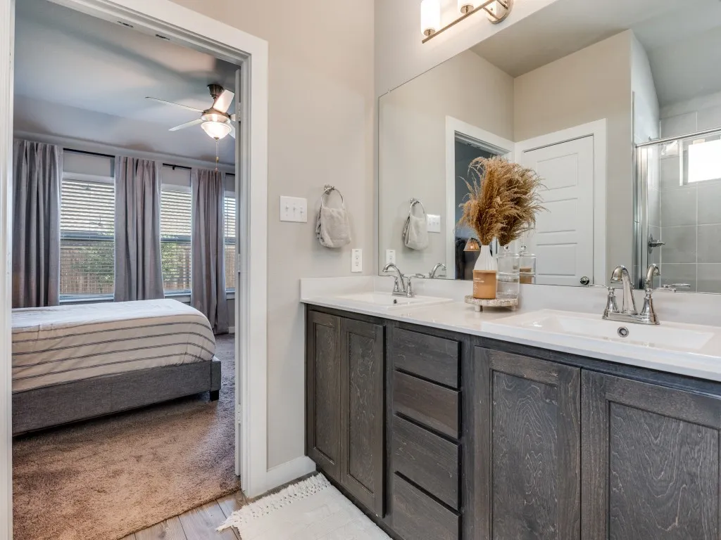 Bathroom vanity featuring dual undermount sinks, white countertops, and dark wood-finish cabinetry