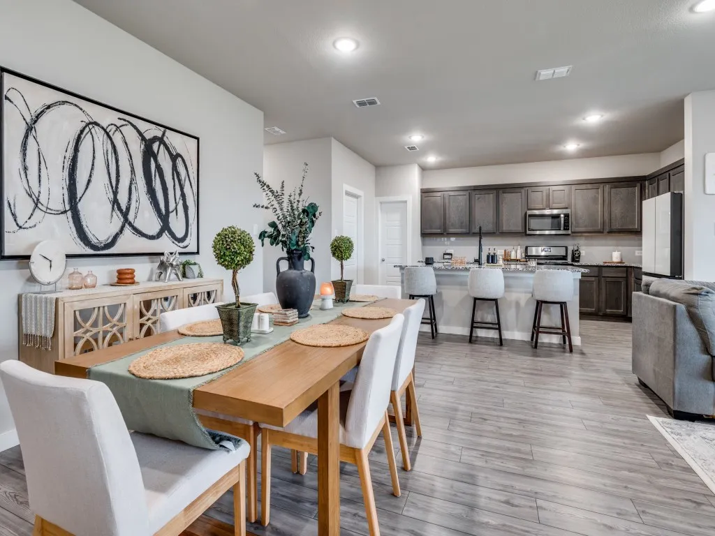 Open-concept living area featuring wood-finish flooring, recessed lighting, and a dining space with a light wood table