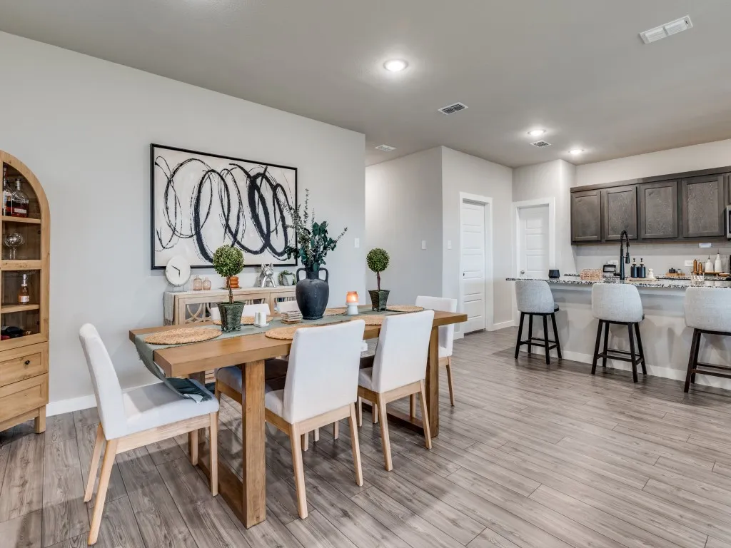 Open-concept dining area featuring wood-finish flooring, a light gray wall color, and recessed lighting