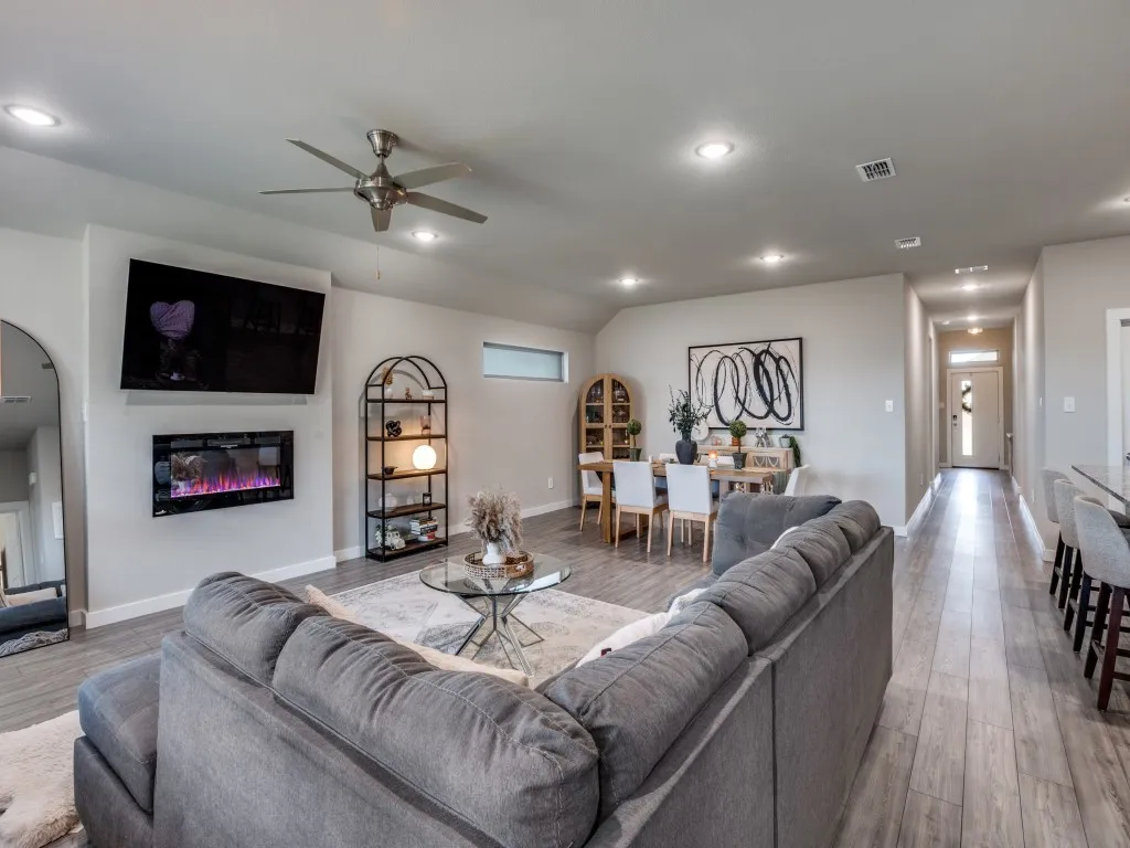 Open-concept living area featuring wood-finish flooring throughout, recessed lighting, and a modern ceiling fan