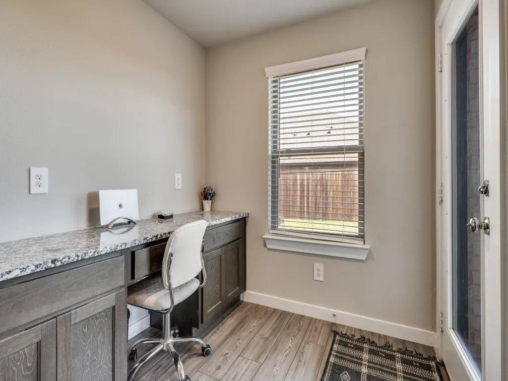 Built-in desk featuring a stone-finish countertop and dark wood-finish cabinetry