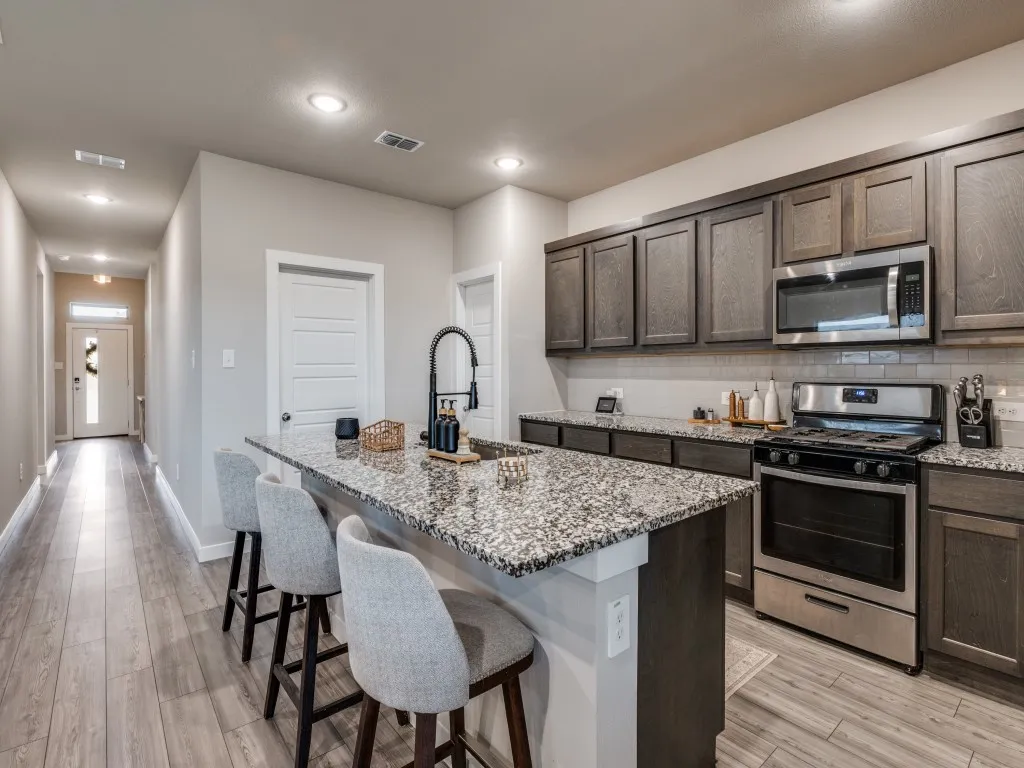Contemporary kitchen with an island featuring a dark base and a speckled countertop