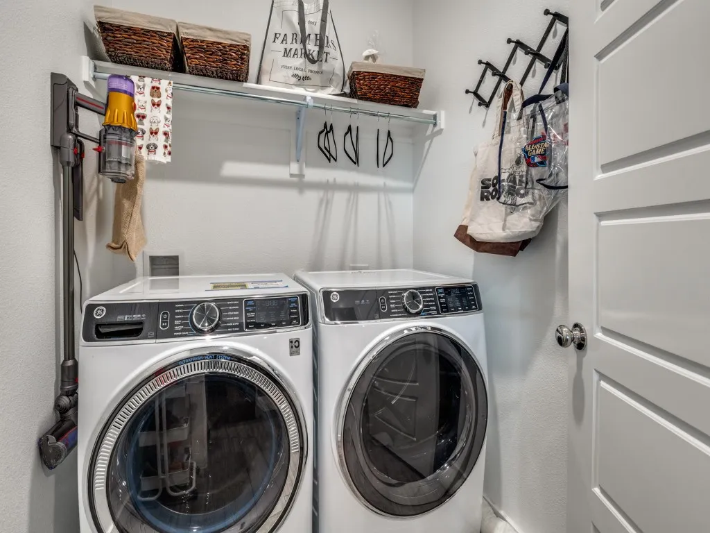 Dedicated laundry area featuring a front-loading washer and dryer set