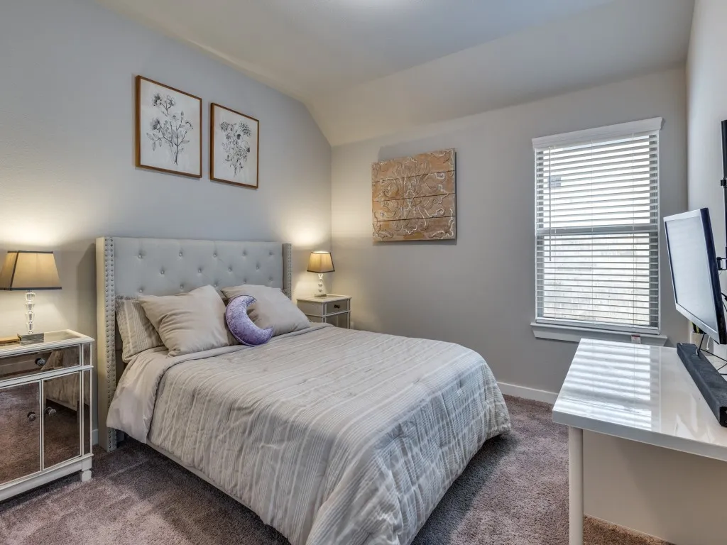 Carpeted bedroom featuring neutral wall tones, a window with blinds, and white trim