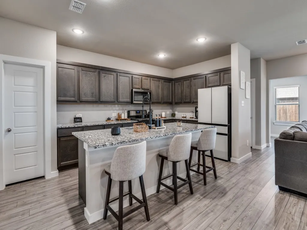 Well-appointed kitchen featuring wood-finish flooring, dark wood cabinetry, and light-toned countertops