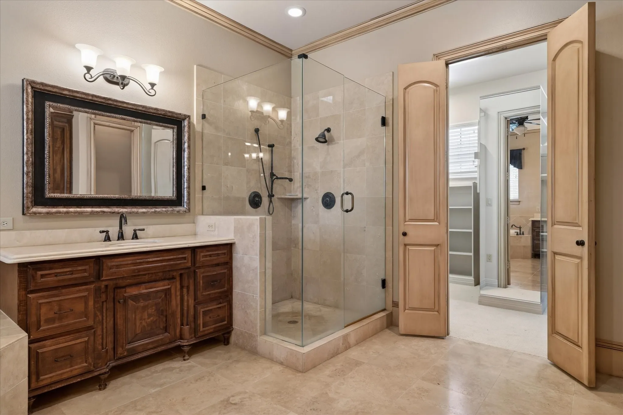 Bathroom featuring a dark wood vanity with a light-toned countertop, a framed mirror, and a glass-enclosed shower with tile surround