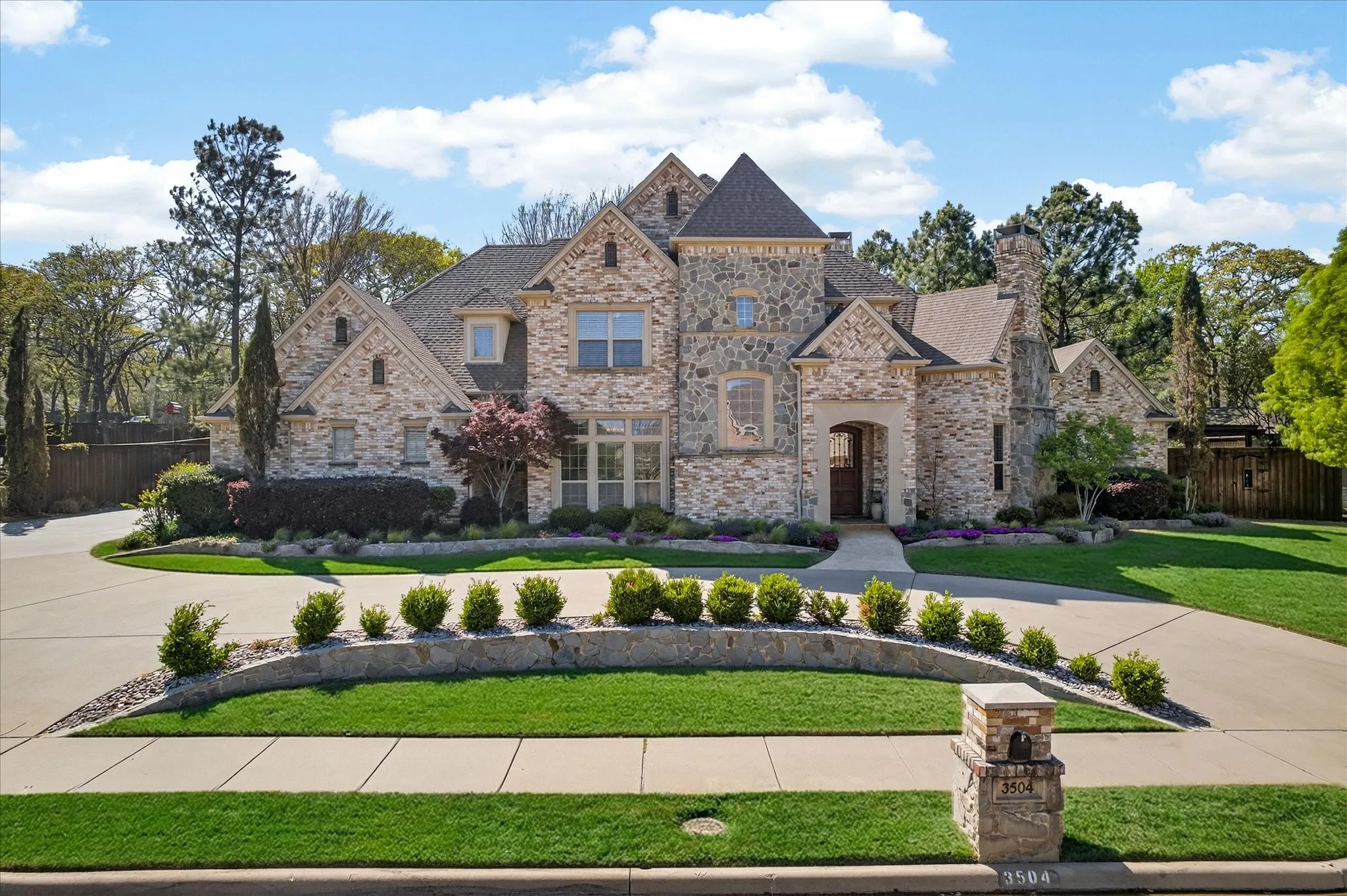 Grand stone and brick exterior featuring multiple gables and a turret