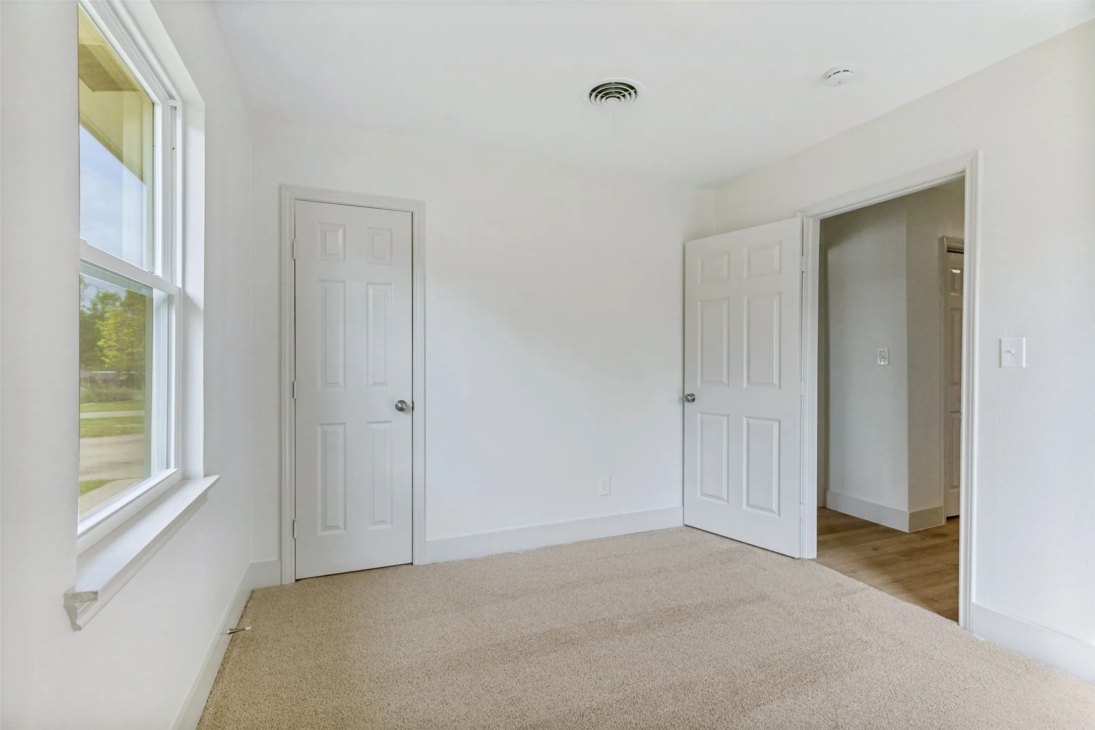Light-toned carpet flooring complements neutral wall tones