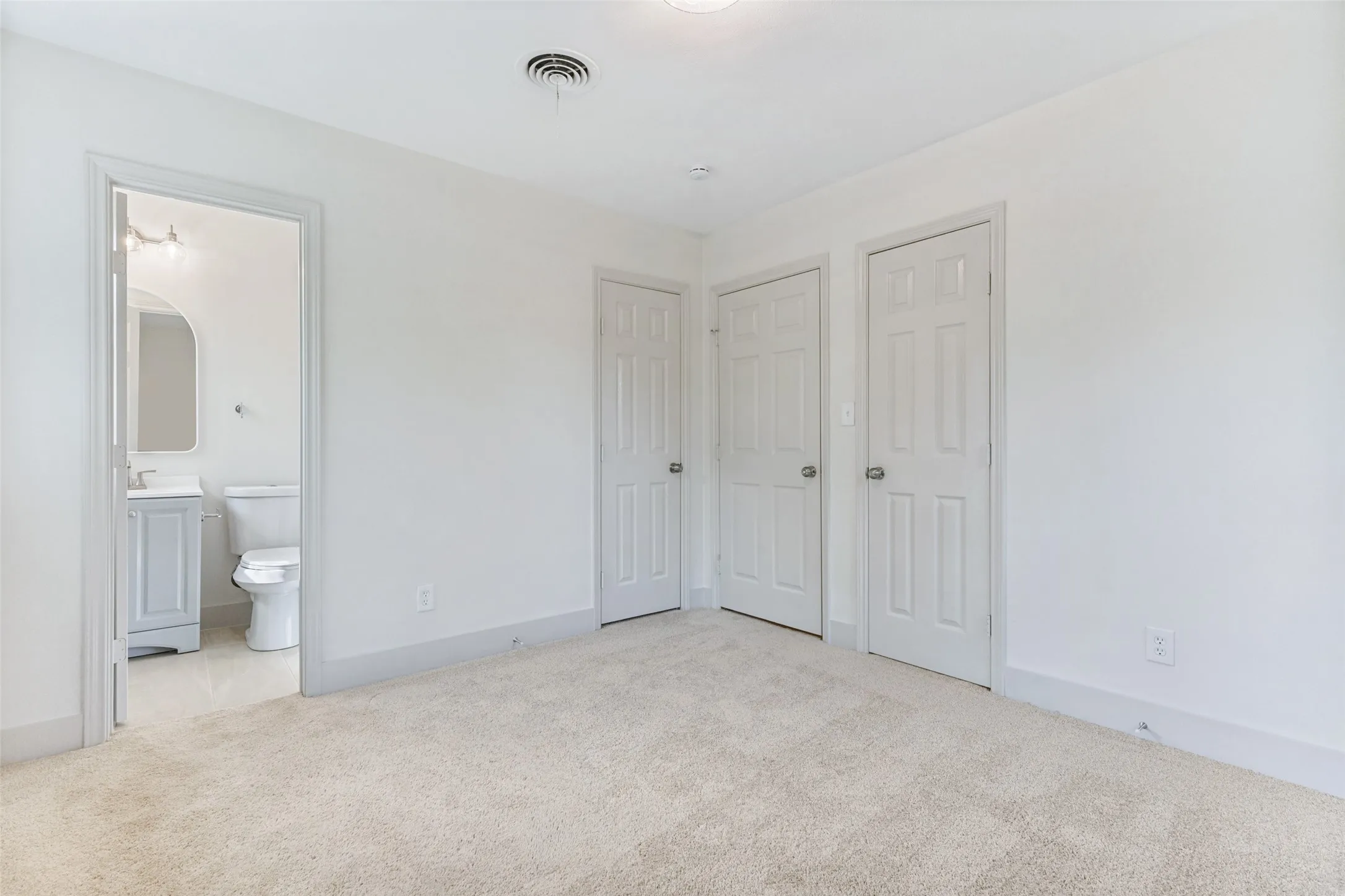 Neutral tone carpet flooring with white baseboards