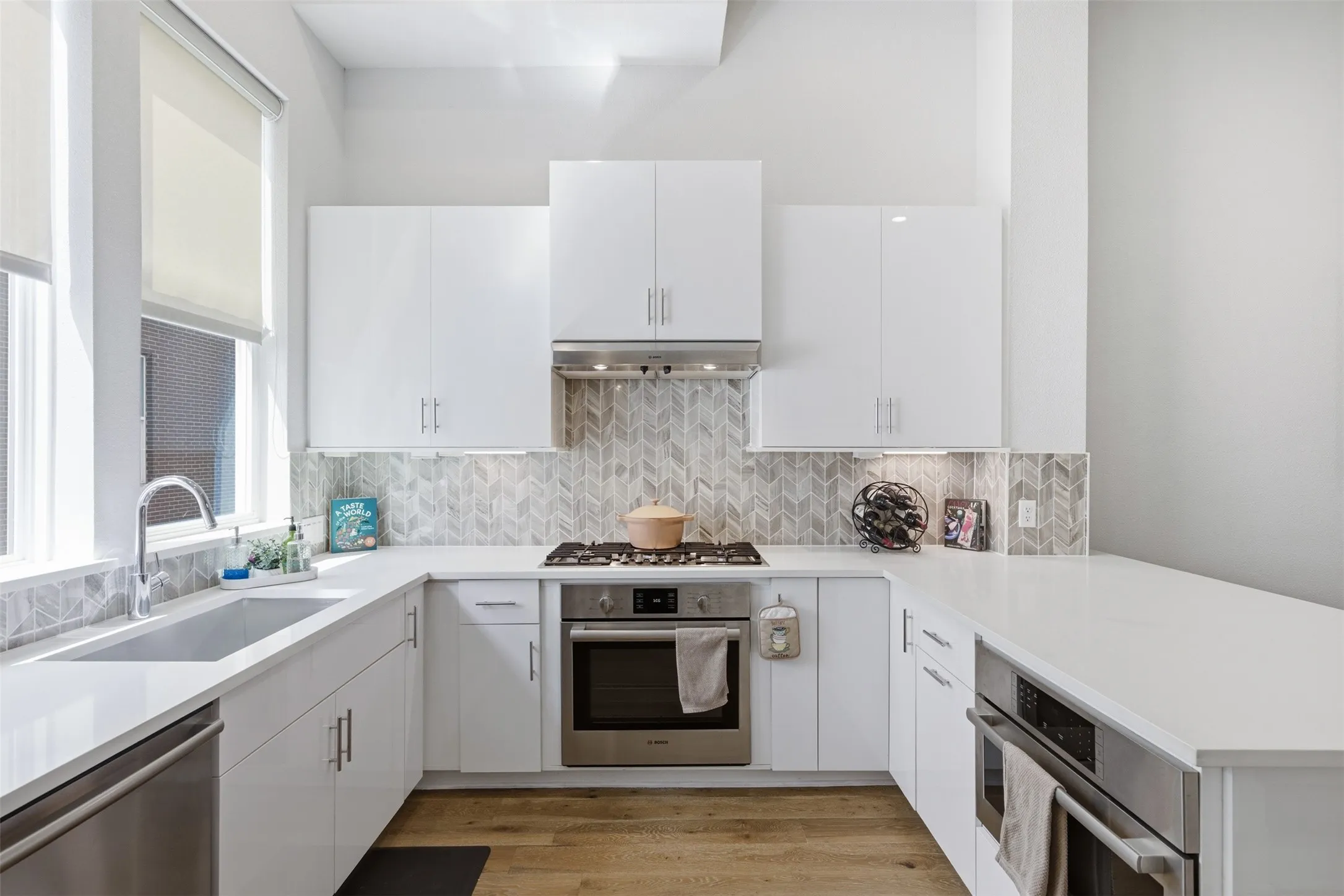 Chef's kitchen featuring Bosch gas range, built-in microwave, quartz counters—ideal for entertaining in this open-concept townhome