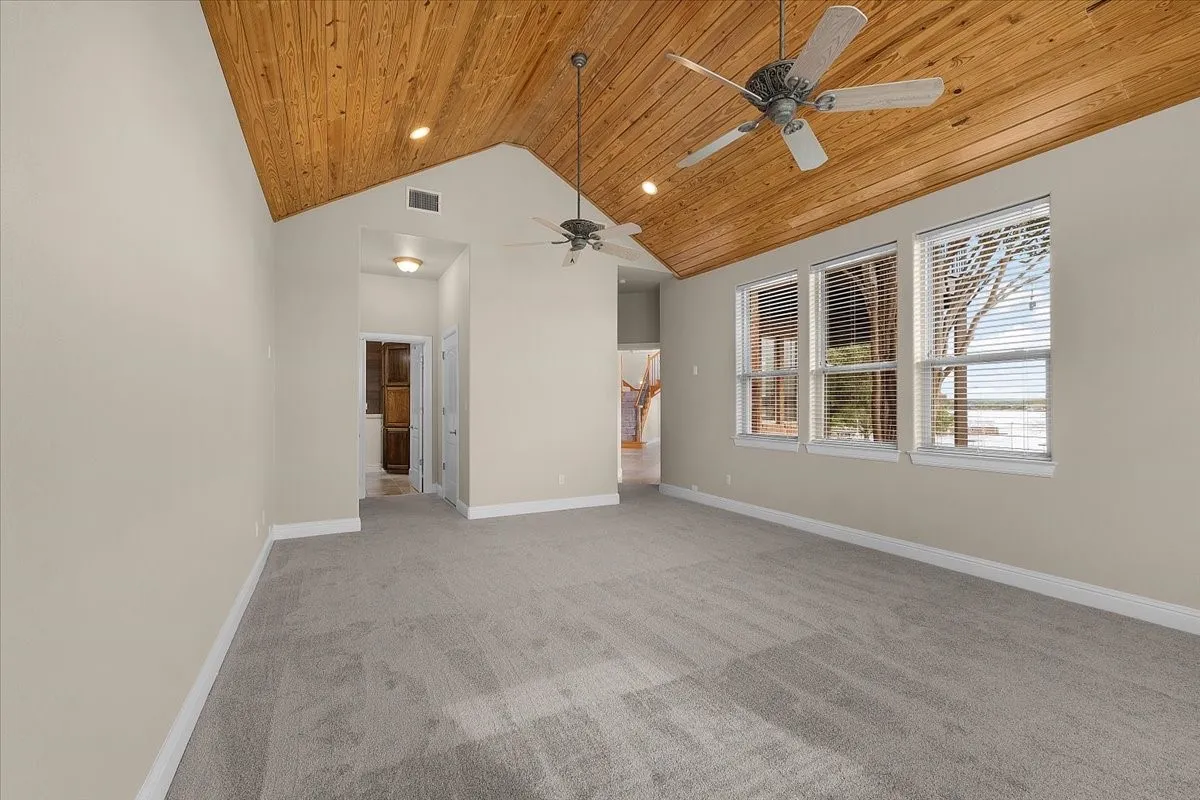 Vaulted wood-paneled ceiling with recessed lighting and ceiling fans