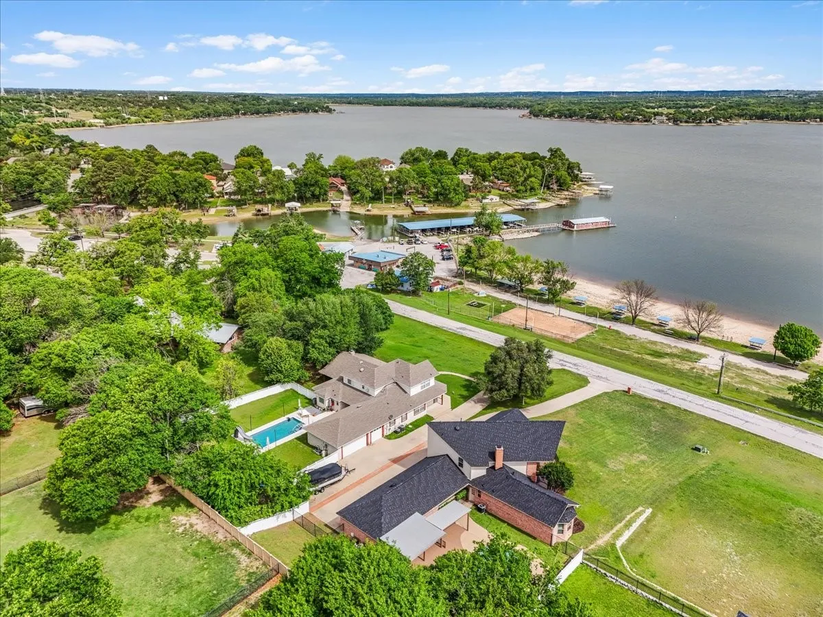 Aerial perspective showcasing a large residential property with a private swimming pool, mature trees, and fenced yard space