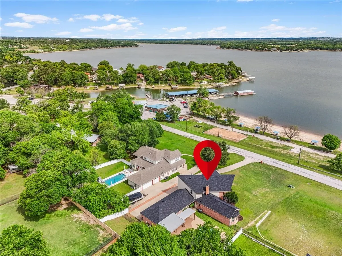 Aerial perspective showcasing a property with a swimming pool, multiple structures, and expansive green spaces