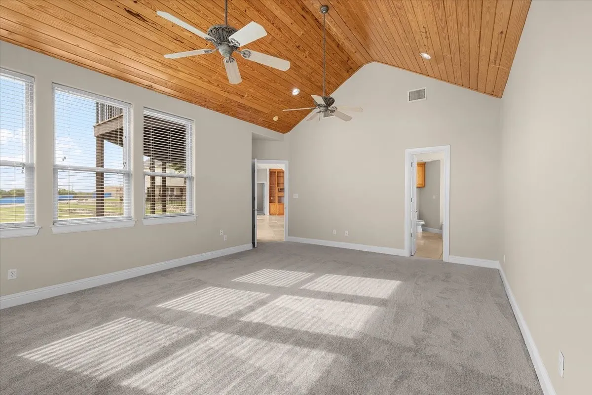 Spacious room featuring a vaulted wood-plank ceiling, recessed lighting, and dual ceiling fans