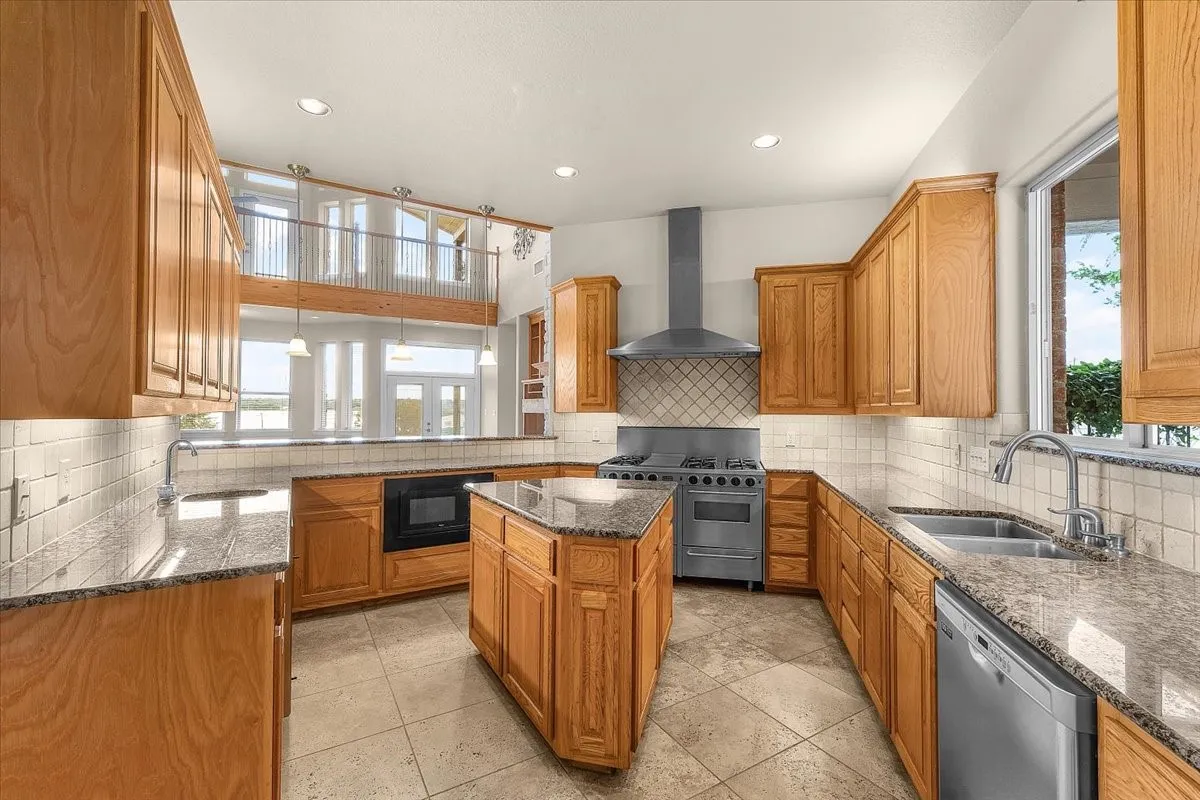 Kitchen featuring wood cabinetry, granite countertops, and stainless steel appliances