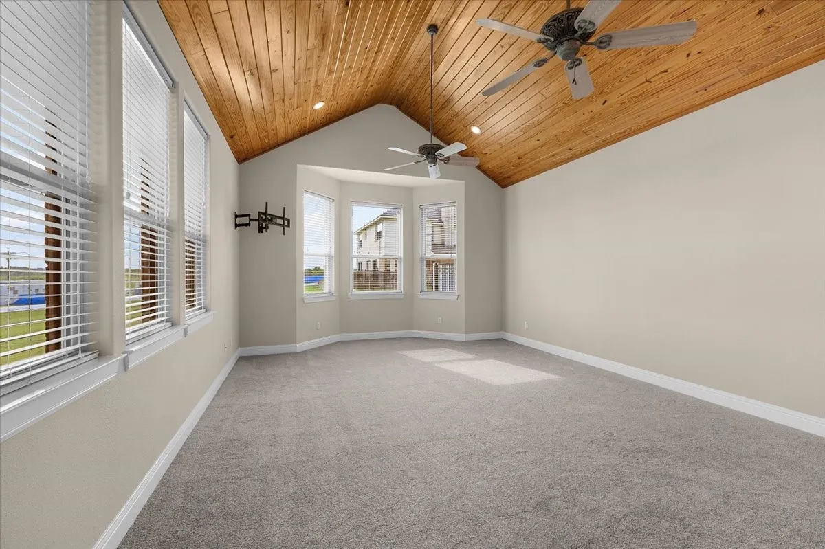 Vaulted wood-finish ceiling featuring recessed lighting and dual ceiling fans