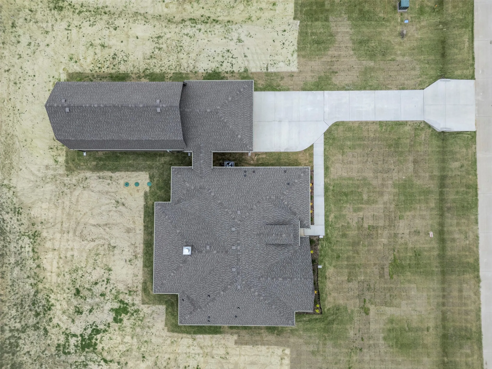 Aerial view showcasing a residential property with a main house and an accessory structure featuring dark gray shingle roofing