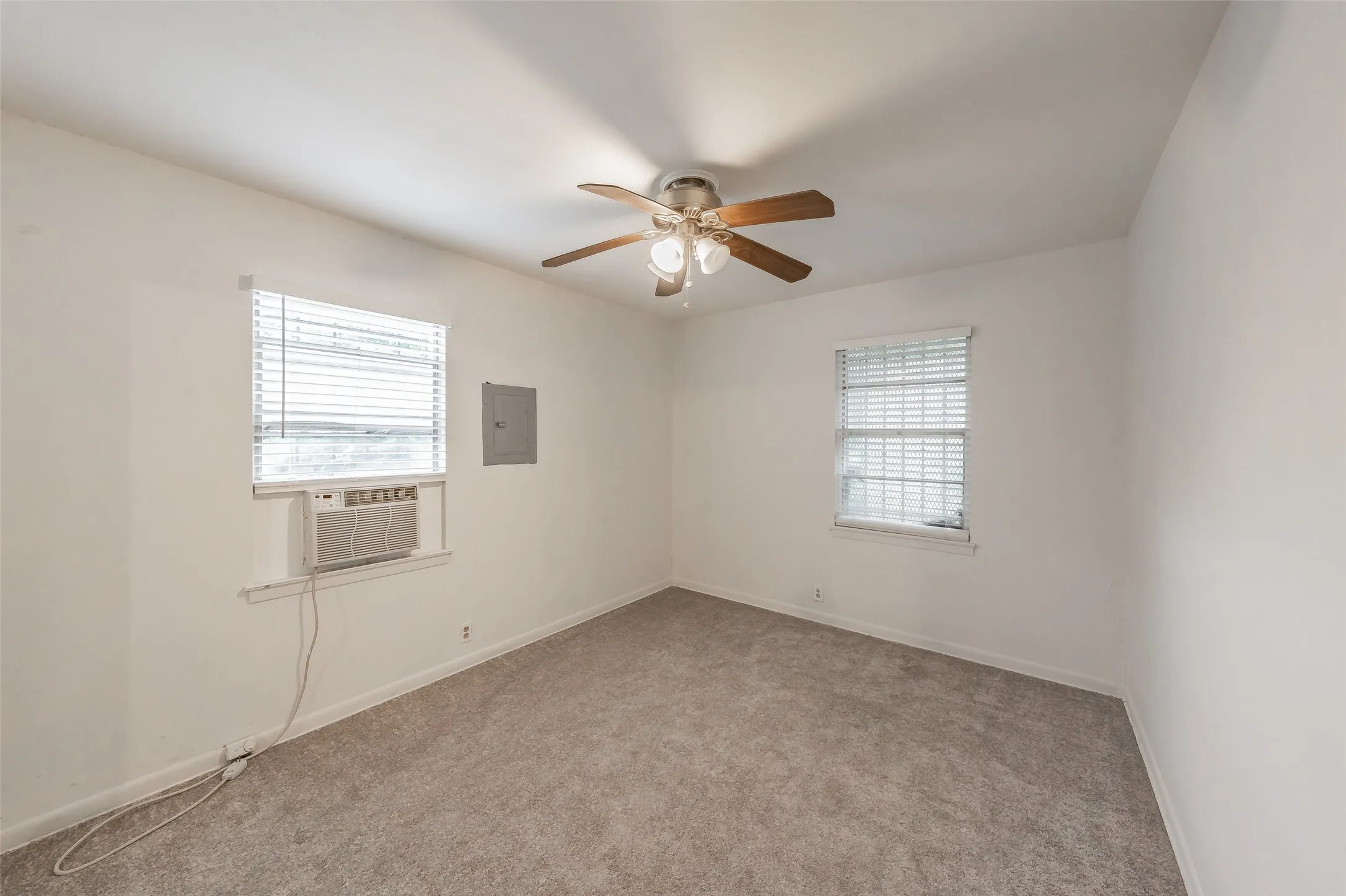 Bedroom 3 Neutral-toned carpet flooring and white walls define this room, featuring two windows with horizontal blinds