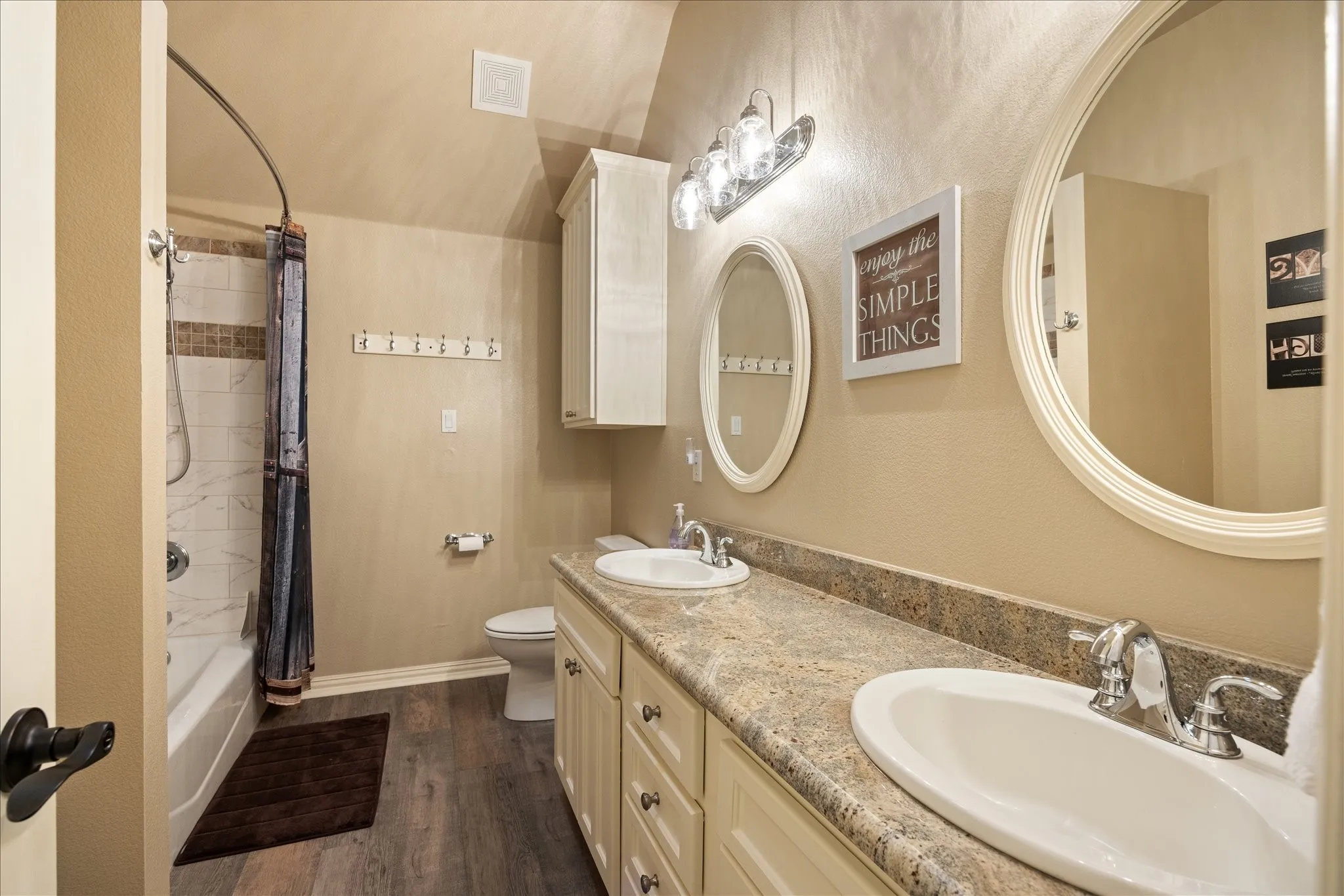 Upstairs bathroom is a full bath with double sinks and neutral colors.