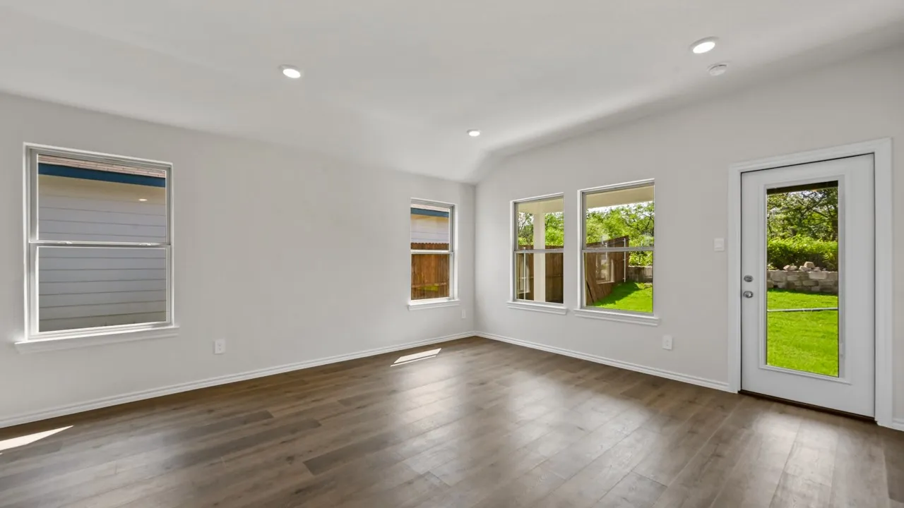 Spacious room featuring wood-finish flooring, recessed lighting, and multiple windows