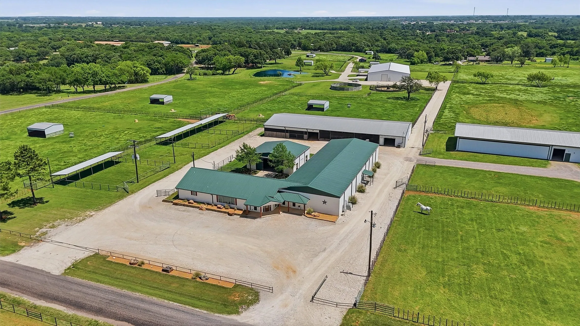 Aerial view from Roland Road showing parking in front of residence and driveways around/thru facilities
