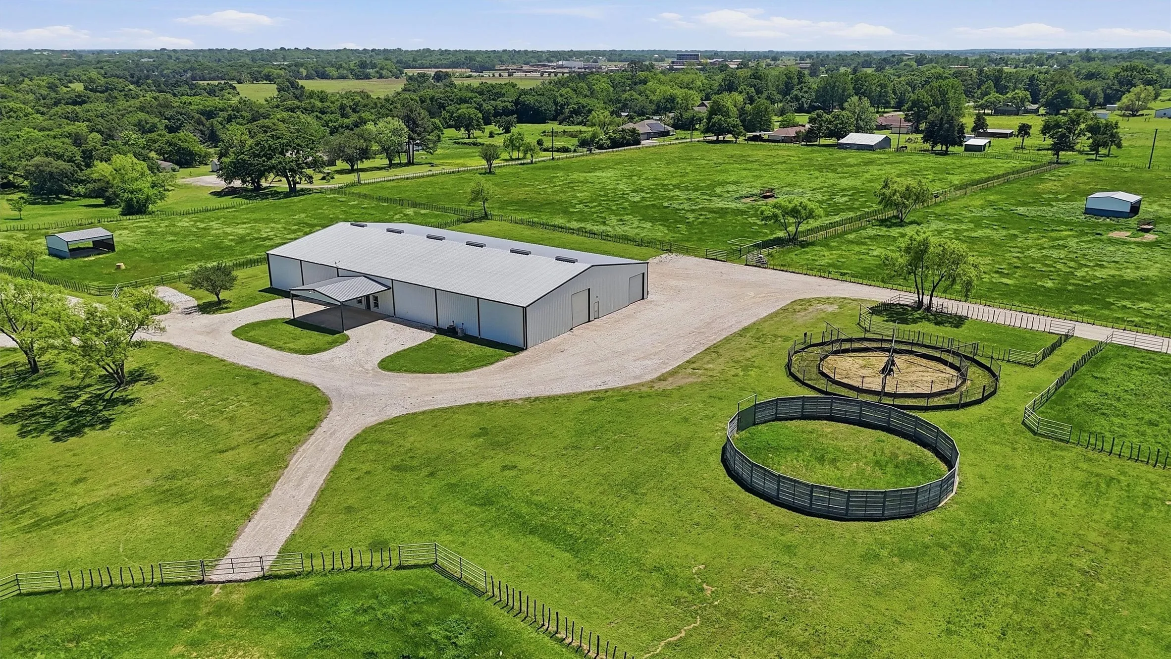 Aerial  view of the Arena Barn-Lab complex showing electric walker, round pend and adjoining turnout pastures