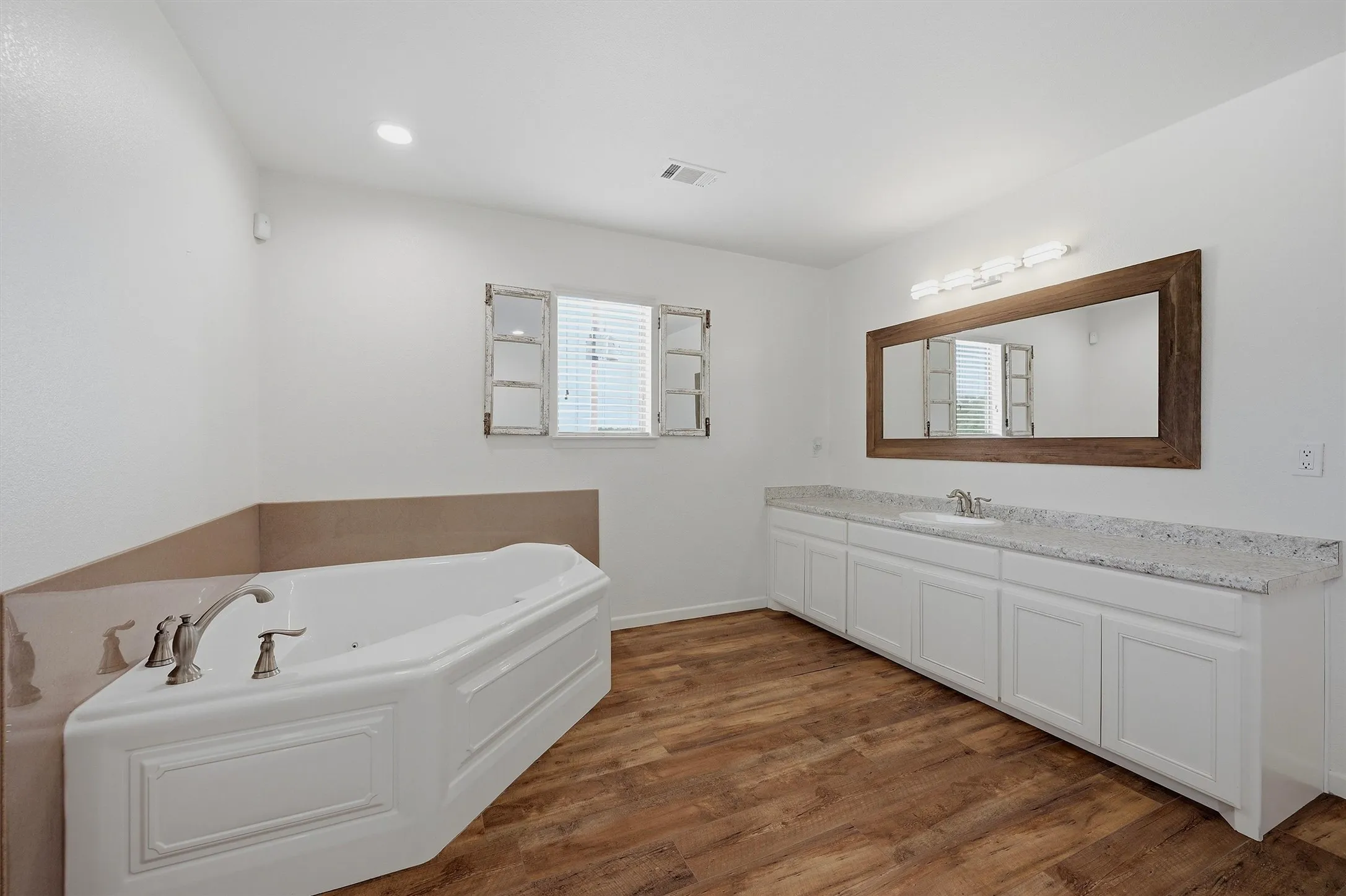 Primary bathroom has an oversized vanity and large soaking tub. Stand-alone shower in adjacent bath