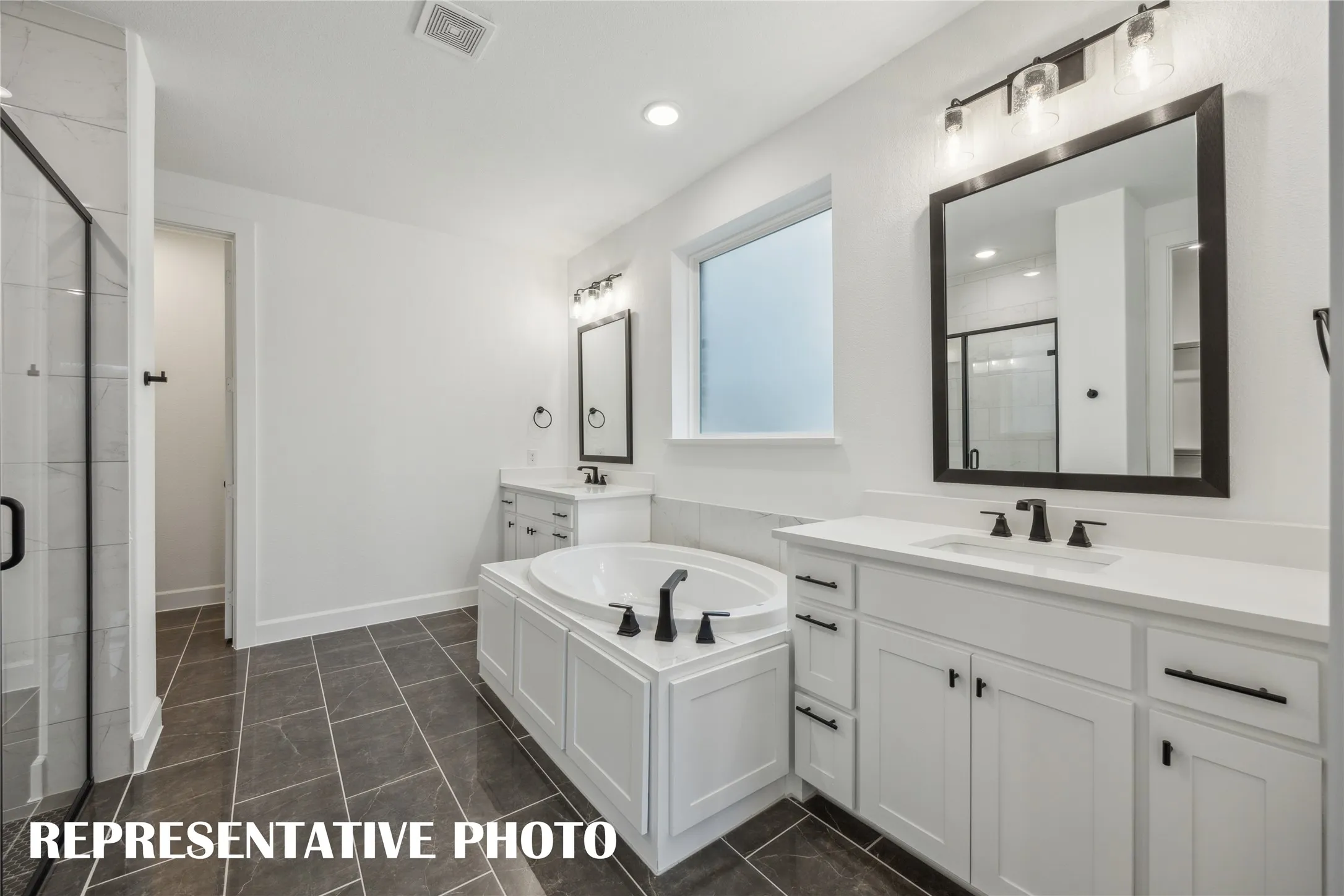 Featuring his & her vanities, gorgeous tub and spacious walk in shower, this owner's bath is a dream come true!  REPRESENTATIVE PHOTO