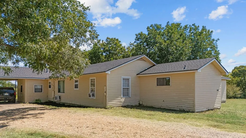 The property features a single-story structure with light-colored siding and a dark-shingled roof