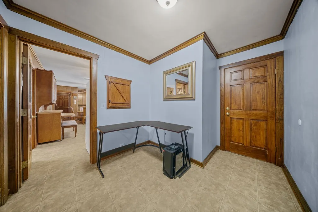 Entryway featuring light blue walls, wood trim, and tile flooring