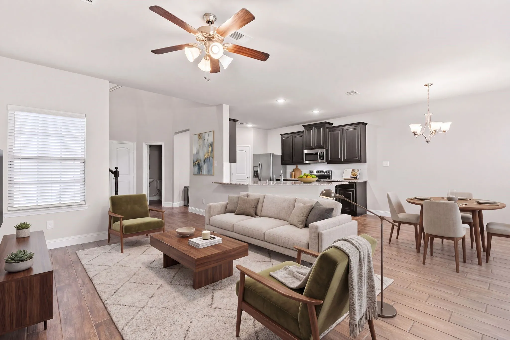 The property features an open-concept living area with wood-look flooring, a ceiling fan, and a dining space with a chandelier