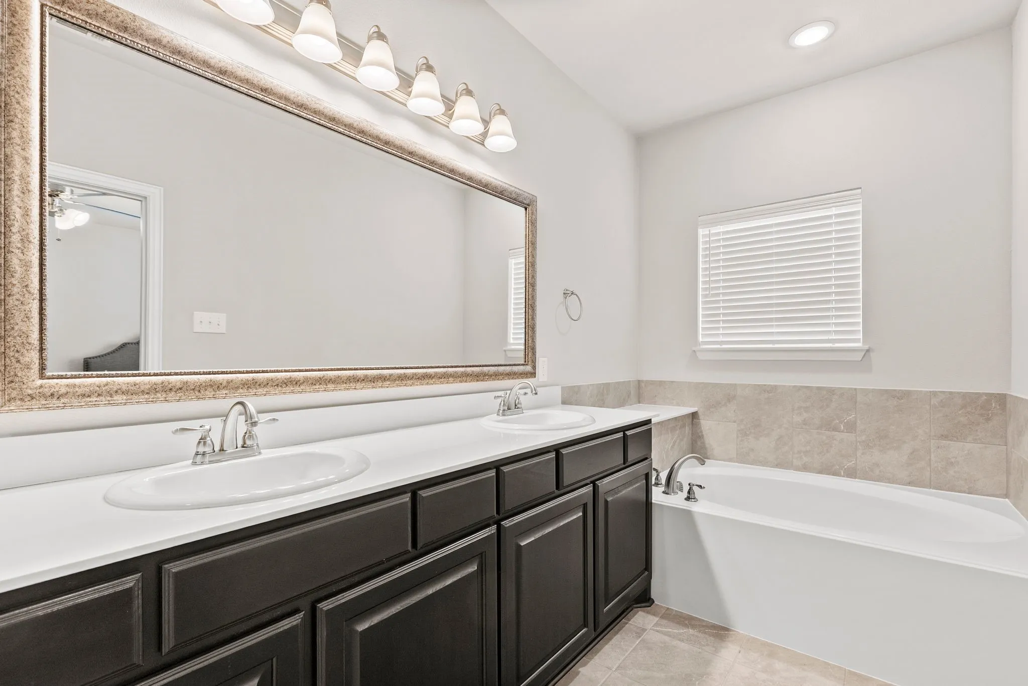 Master Bathroom featuring a double vanity with dark cabinetry, white countertops, and chrome fixtures