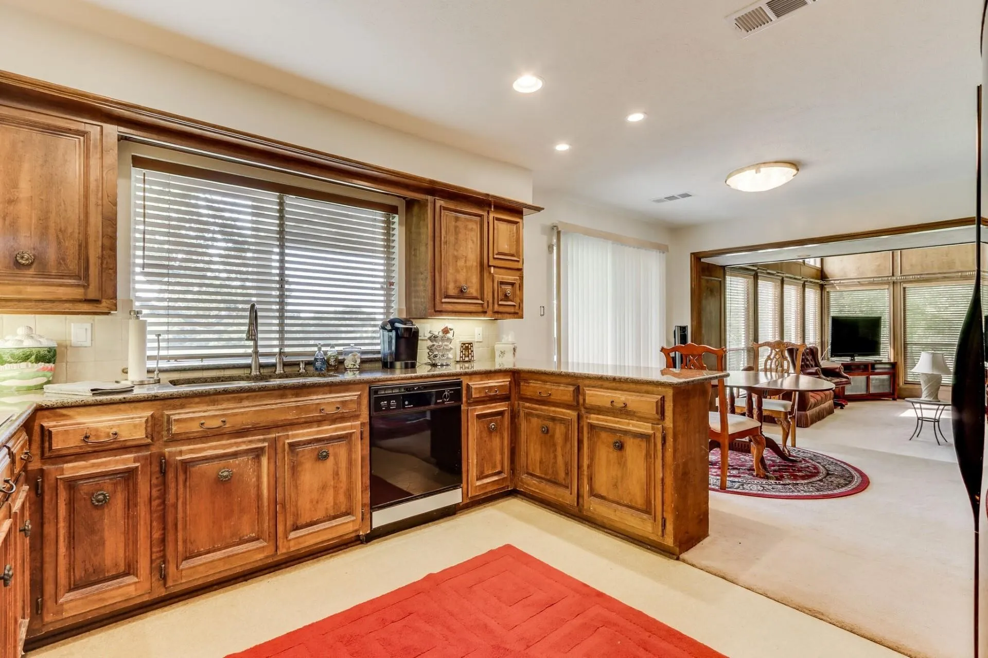Kitchen with wood cabinetry, granite countertops, and a stainless steel sink