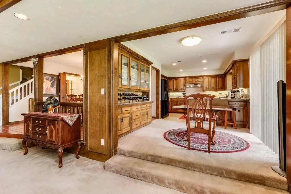 Kitchen with wood-finish cabinetry and undermount lighting