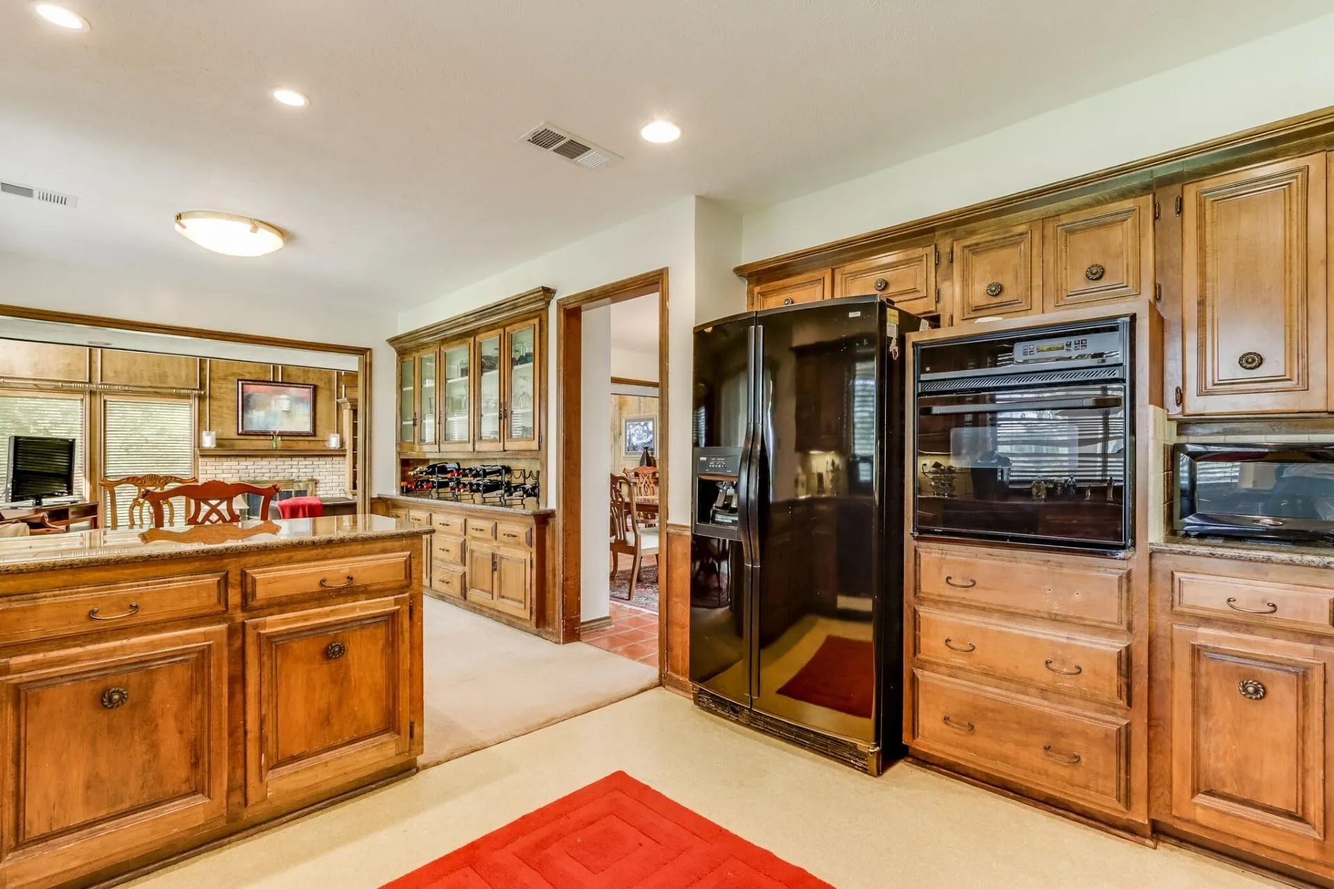 Kitchen featuring wood cabinetry, a built-in oven, and a black refrigerator