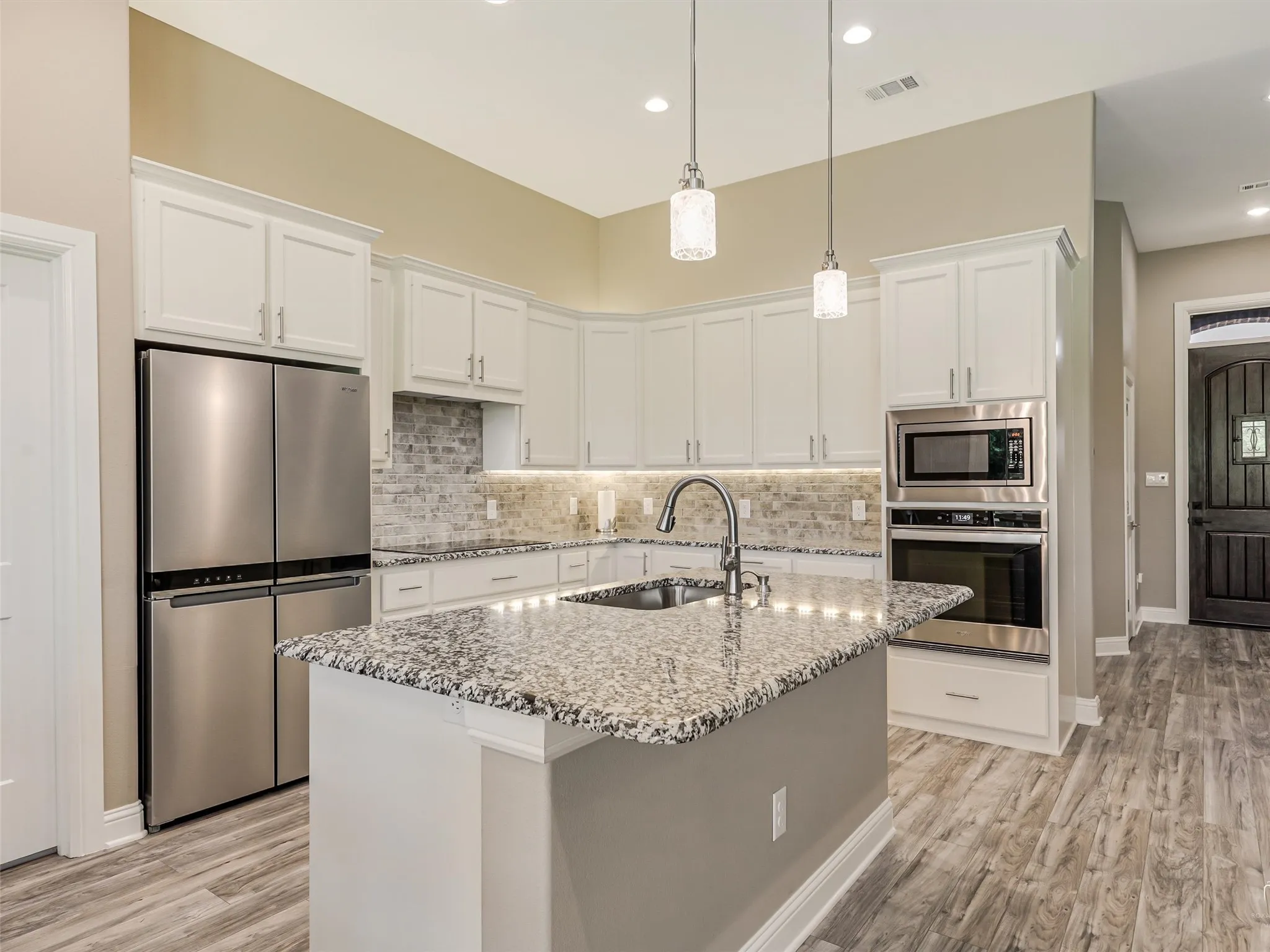 Kitchen with oversized island and large walk in pantry is flooded with natural light.  You will love entertaining in this open concept home