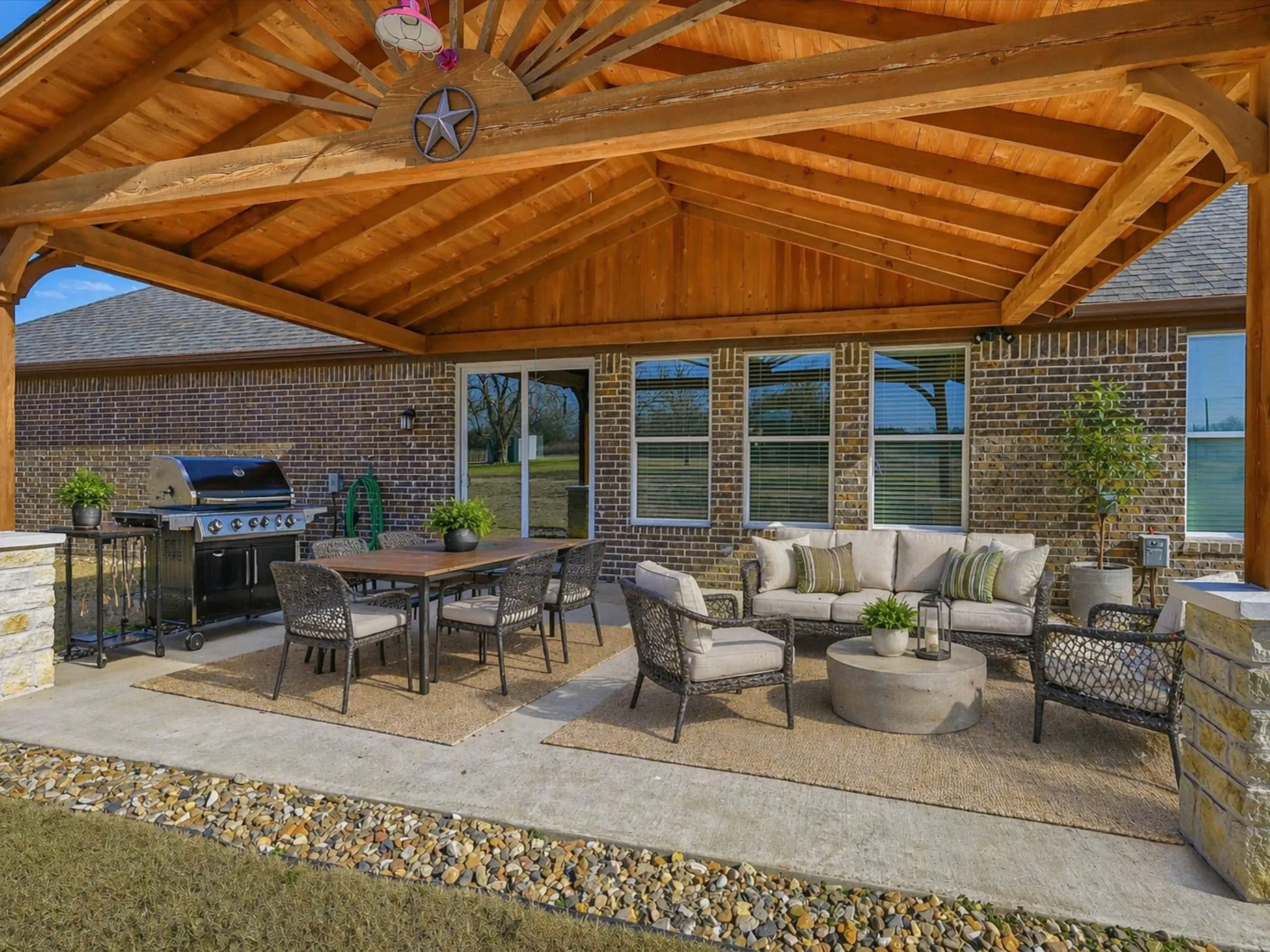 An entertainer’s dream unfolds under this stunning covered patio, where warm wood tones and open-air comfort invite effortless gatherings year-round. Imagine evenings filled with laughter, grilling, and relaxed conversation in a space designed for both connection and quiet retreat.
