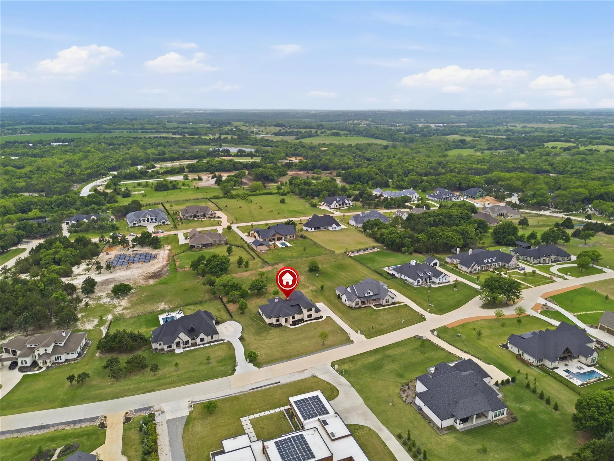 Expansive residential setting featuring varied home styles with dark-pitched roofs and light-colored exteriors