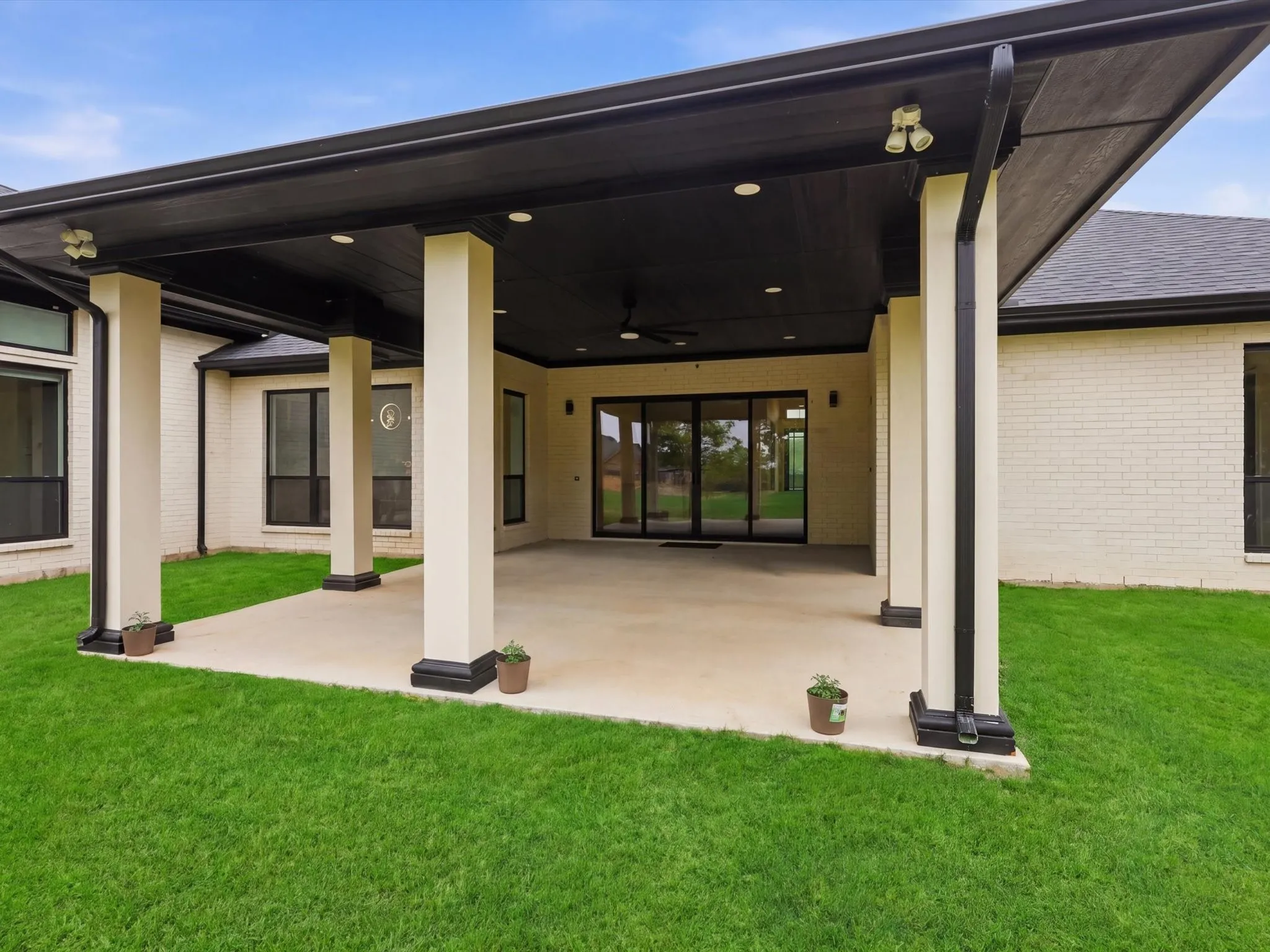 Covered patio with recessed lighting, ceiling fan, and black trim details, plumbed gas line for an outdoor kitchen