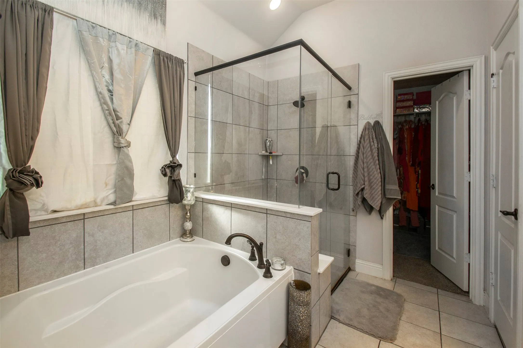 Tile-surround soaking tub with bronze-finish fixtures
