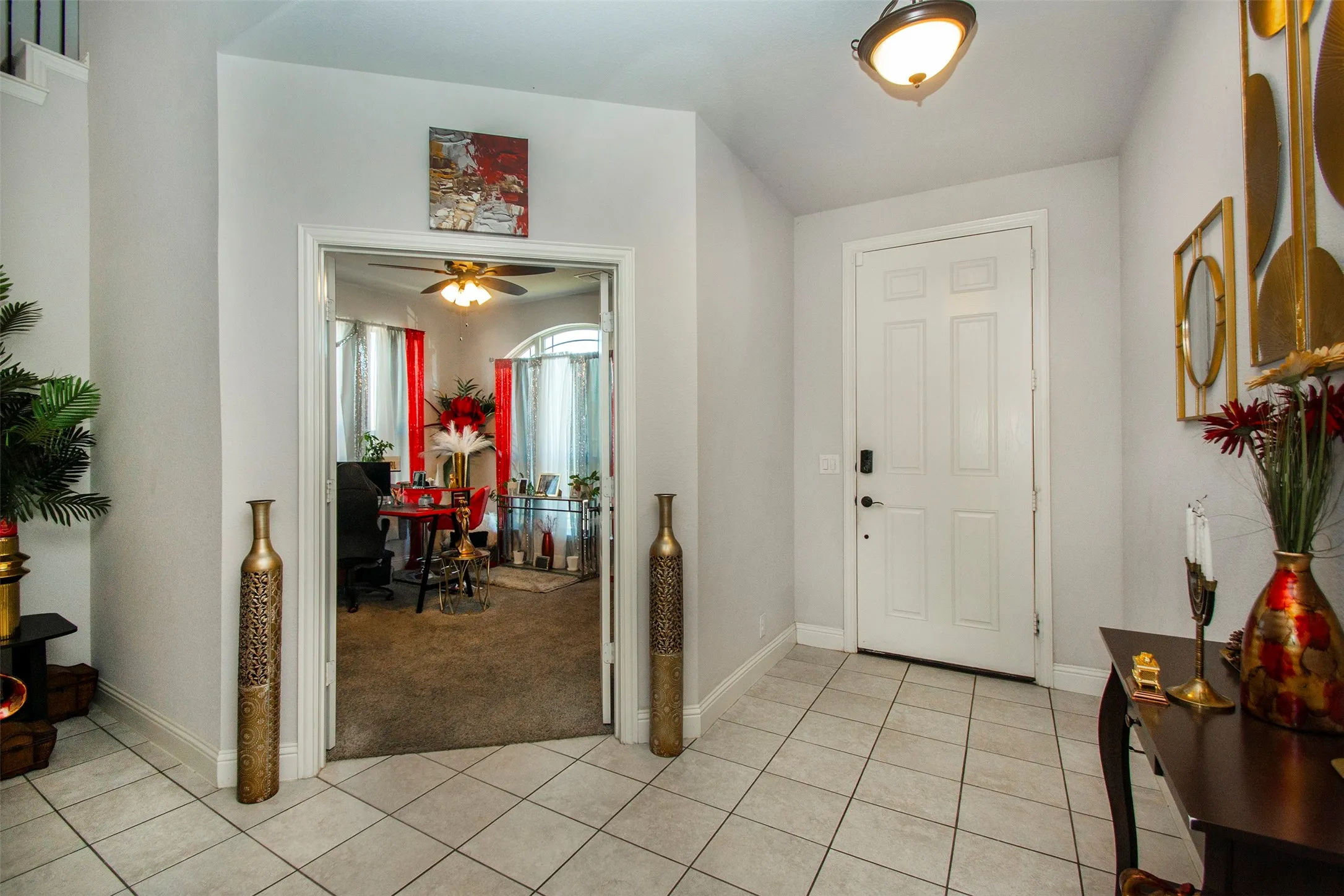 Tiled entry foyer with a paneled front door and overhead fixture