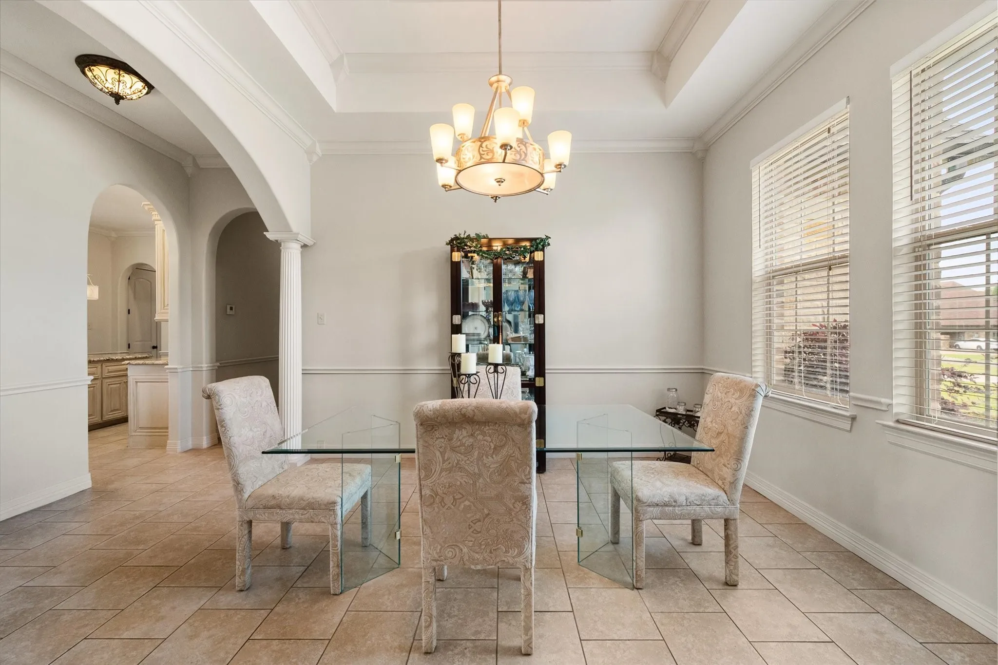 Formal dining area featuring a tray ceiling, crown molding, and wainscoting