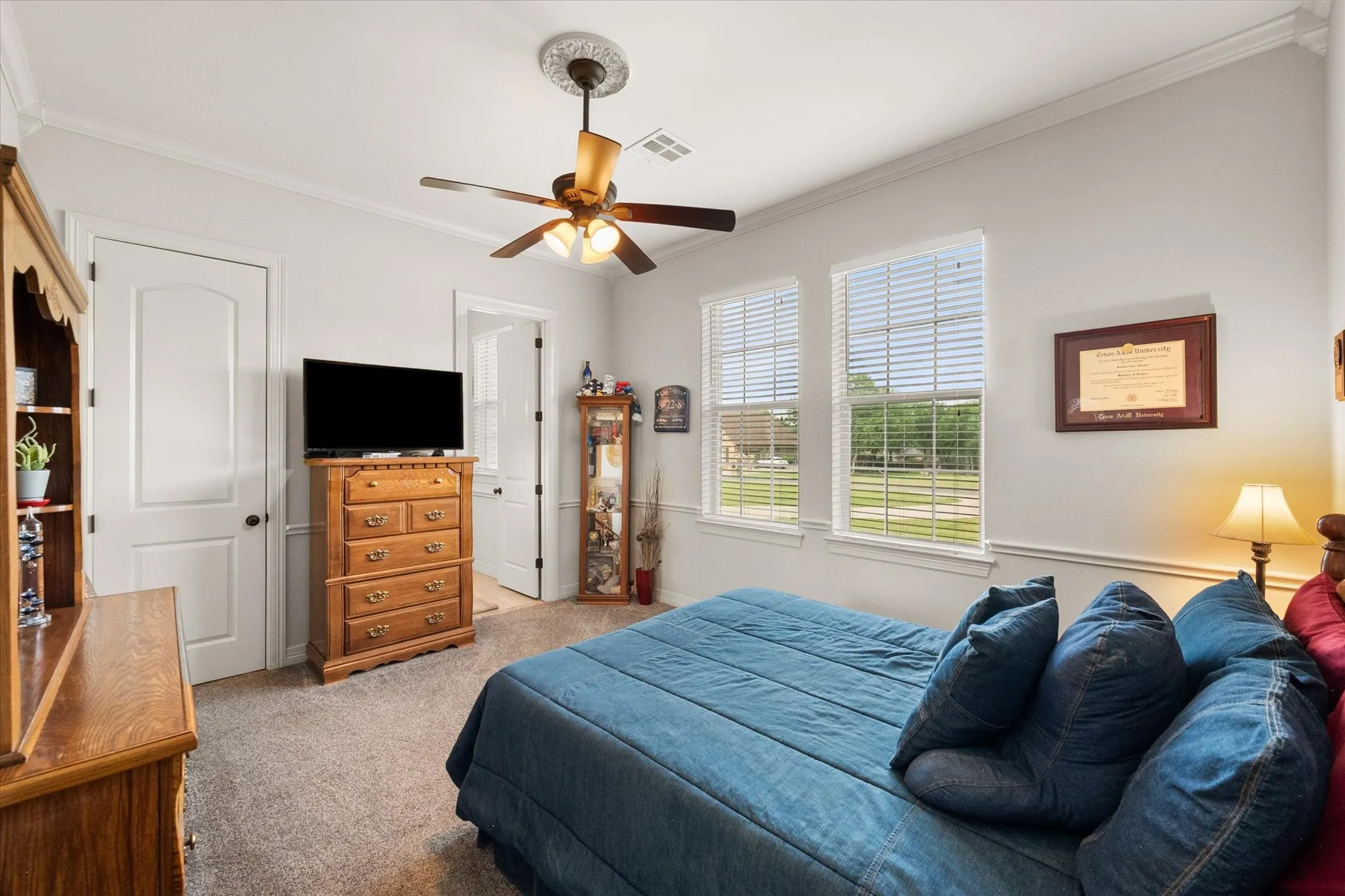 Guest bedroom featuring crown molding and a ceiling fan with light fixture