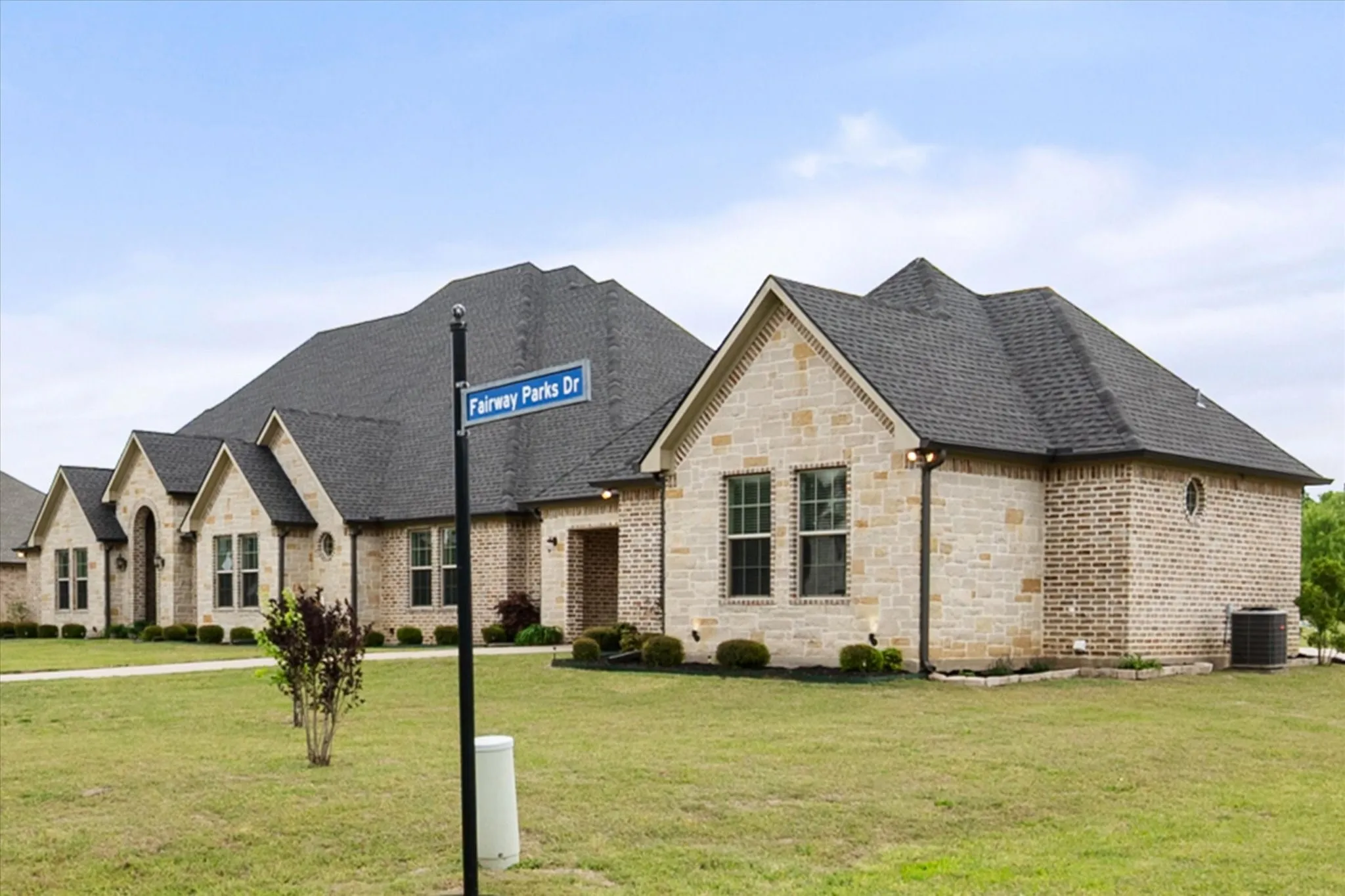 Stone and brick facade with dark shingle roof