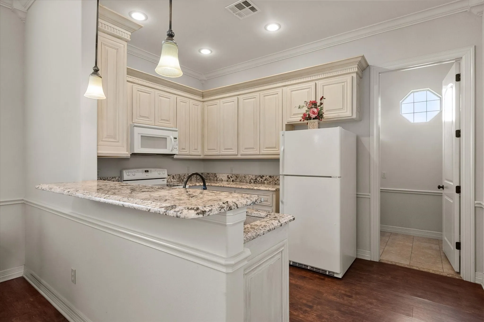 Kitchen in the guest apartment featuring light-toned cabinetry, granite countertops, and recessed lighting