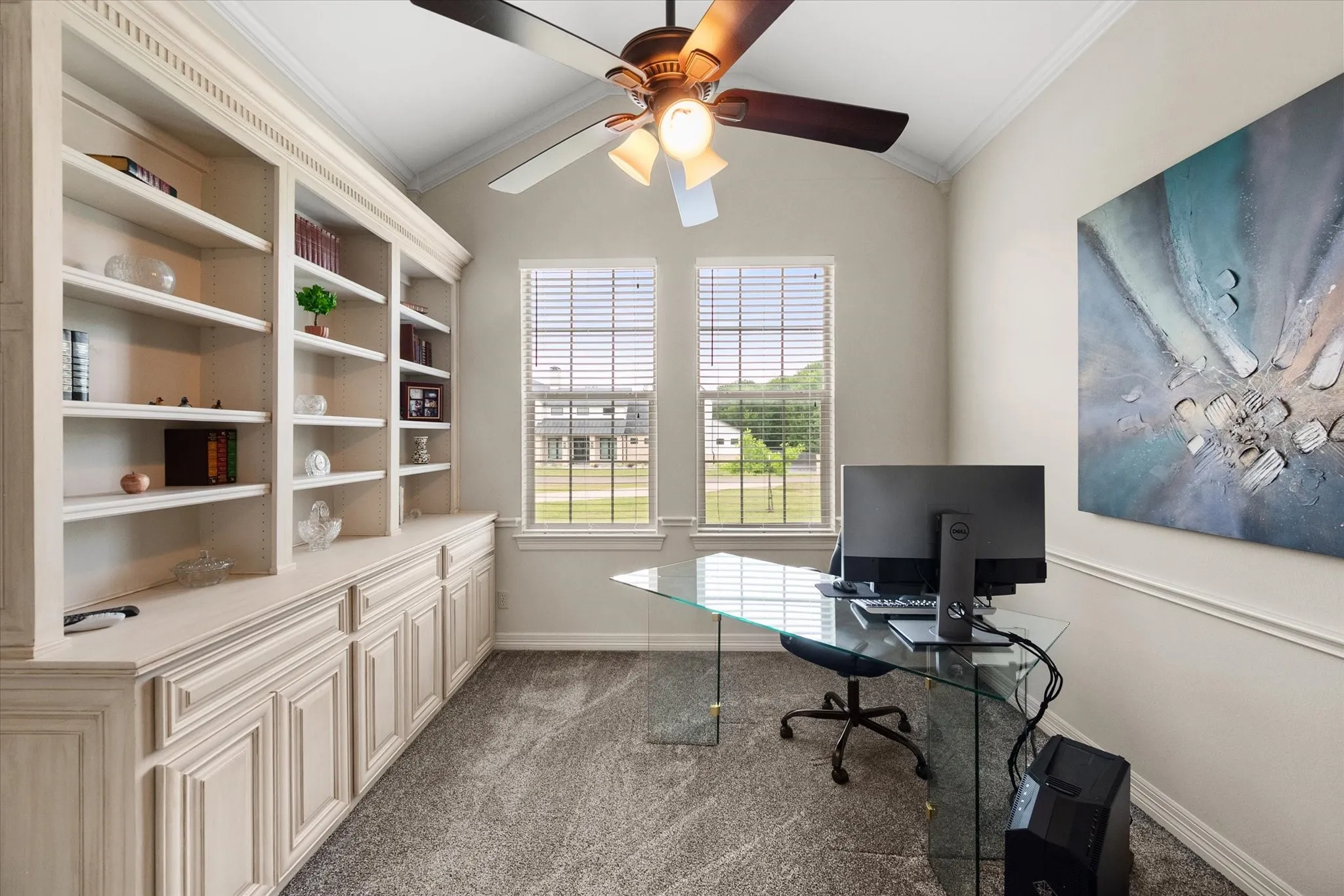 Dedicated room featuring extensive built-in cabinetry, shelving, and two windows with blinds