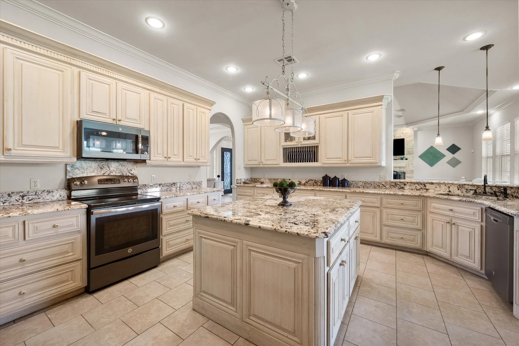 Kitchen with light-colored cabinetry, granite countertops, and tile flooring
